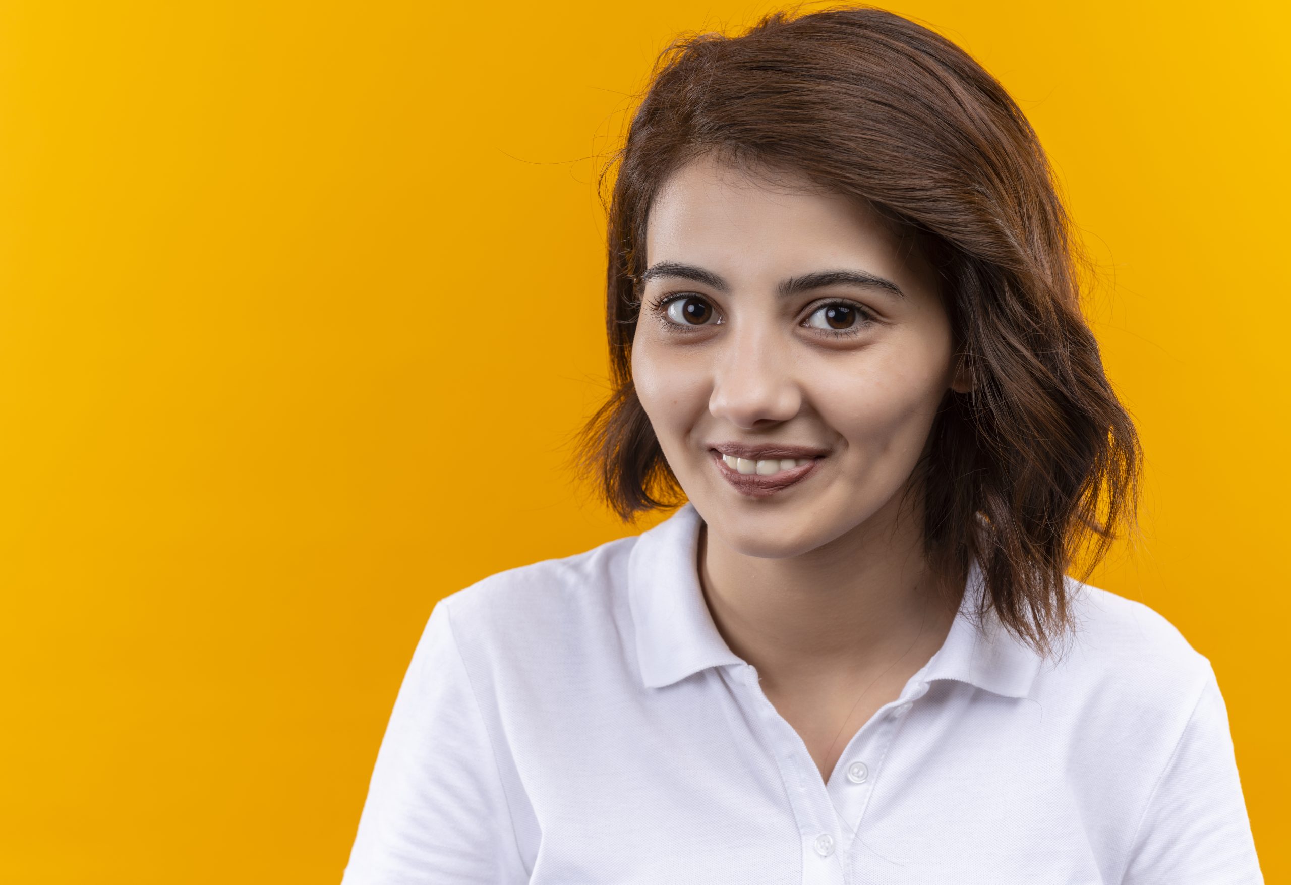 young girl with short hair wearing polo shirt looking camera with smile face scaled